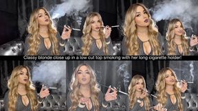 Classy blonde close up in a low cut top smoking with her long cigarette holder!