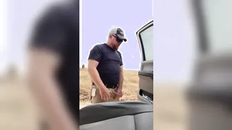 Hairy bear takes a piss outdoors in the countryside