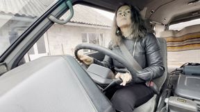 Driving car in leather jacket and patent leather boots aV