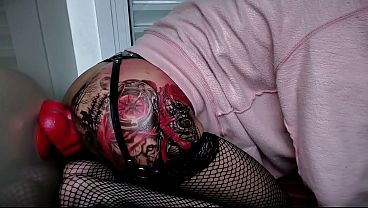 Huge red dildo destroying the ass of the tattooed shemale