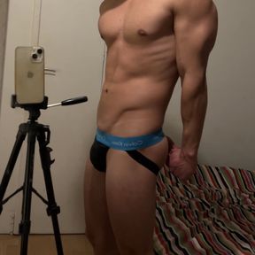 Young fit guy flexing in a jockstrap