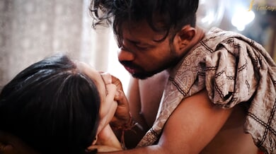 Dark-haired beauty in white lace embraces passion with bearded lover in ornate bedroom