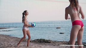 Two lesbian teens play volleyball on the public beach