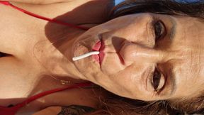 Melissa Johnson sucks and licks a cherry lollipop on the .beach
