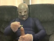 Jacking off condomed dildo with lotion in full blue spandex suit