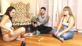 Two girls and one guy are playing a strip game of spin the bottle