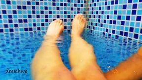 Pies en la piscina con agua