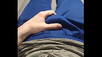 A guy in blue sweatpants rubs his bulge