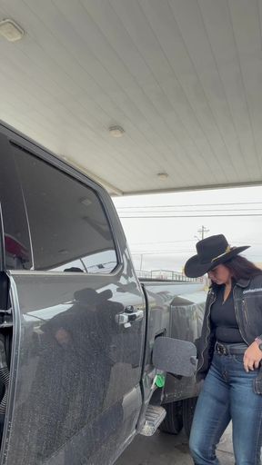 Woman in cowboy hat standing next to truck