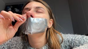 Sneezing with mouth taped and wiping nose with tissues