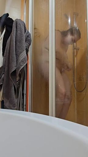 A busty BBW showering in the shower cabin, shaving her armpits, pussy, and legs.   Clip 1