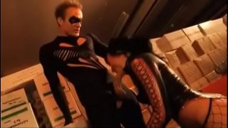 Een cosplayer van een superheldin zuigt piemels en neukt in een magazijn.