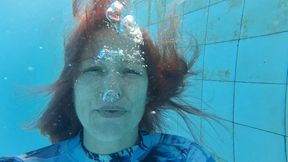 Underwater talking and blowing bubbles in a long sleeve swimsuit