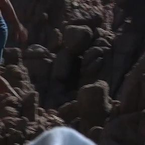 She Lies Naked on the Beach While He Watches Her