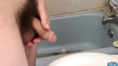 Naughty guy pisses in the toilet and plays with his hard cock