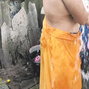 Indian house wife bathing outside