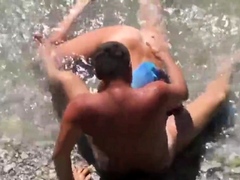 Girl sucks dick her boyfriend in the surf at a public beach