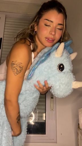 Woman hugging blue unicorn plushie