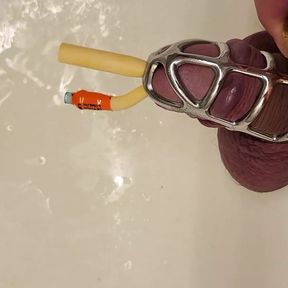 Pissing with catheter locked in chastity cage