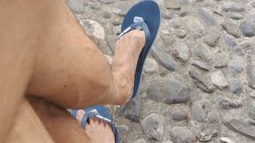 Shoeplay on a public bench with flip flops and dried out feet