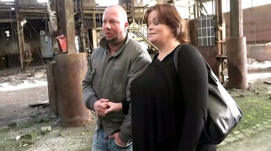 Mature brunette in stockings gives oral to tattooed man in abandoned industrial ruin