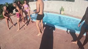 Tug-of-war between women and men next to a pool
