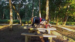 Trans person in pvc outfit enjoys machine sex on picnic table
