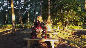 Trans person in pvc outfit enjoys machine sex on picnic table