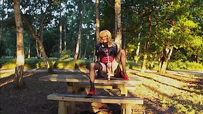 Trans person in pvc outfit enjoys machine sex on picnic table