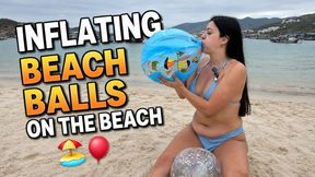 inflating big beach balls on the beach