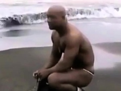 Asian bodybuilder barely covered at the beach
