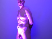 Man posing naked in a blue light his uncut cock shaved and flaccid shows off his nude body