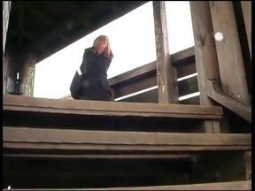 Horny girl sticks  a long dildo into her shaved pussy outdoors