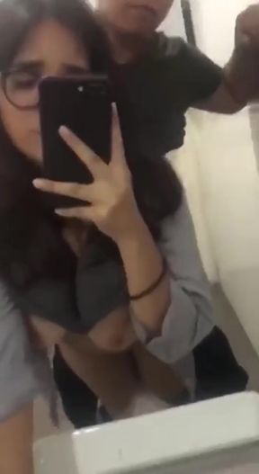 Indian woman takes selfie with her dog in a bathroom, moaning as she stands in t