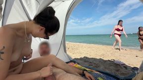 Experienced brunette gives her lover a handjob on a sandy beach