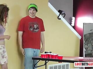 Three girls and one guy play a game of strip beer pong