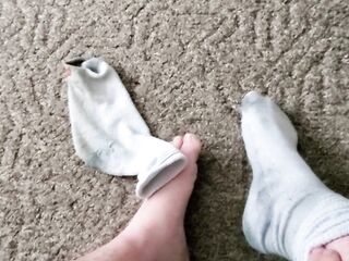 Takes perspired, ribald work socks off and shows feet!
