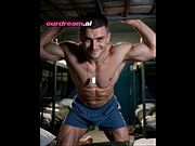 Shirtless Army Stud Mace Grins Under a Bunk in Blue Shorts