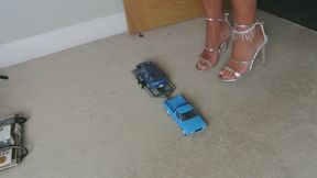 Nikkichick crushes a pickup and car on a trailer in high heels with painted toe nails toy car crush low right view