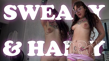The sweaty tattoo girl smells her dirty clothes after working out.