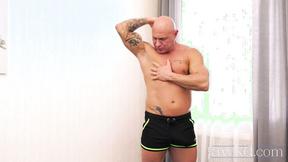 ”Muscular tattooed hunk Den Fitness strokes his hard meat solo”