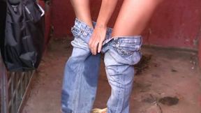 Skinny long-haired brunette pees in her jeans in a public place