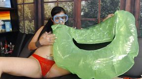 Blowing up green pool toy in snorkel mask