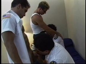 Hairy fireman sits back on a bed and enjoys gay orgy