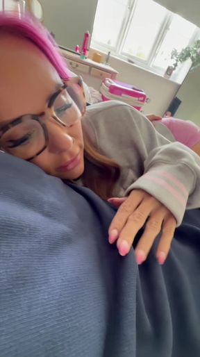 Sleepy couple cuddles in bed while rubbing each other