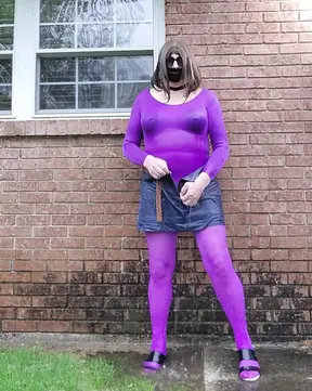 Crossdressed outdoors in nylon bodysuit getting wet in the rain.