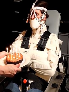 Straitjacket & Muzzled Girl Tries To Blow Out Candles