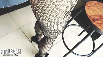 Shoe dangling with fishnets and black high heels
