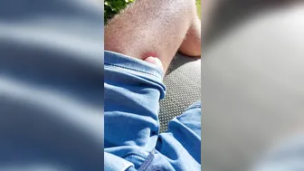Slim twink rubs his huge erection through trousers in sunny garden