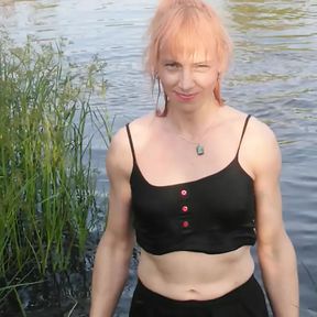 Transgirl swimming in clothes in lake wearing all black: pantyhose, skirt and top. Wetlook in lake.